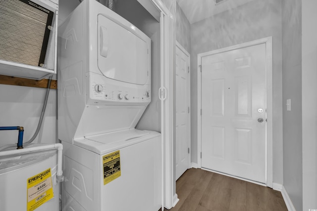 901 W Port Dr Unit 1706, North Myrtle Beach, SC 29582 - laundry area with wood finished floors, stacked washer / dryer, laundry area, electric water heater, and baseboards