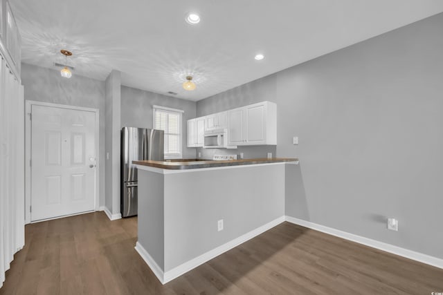 901 W Port Dr Unit 1706, North Myrtle Beach, SC 29582 - kitchen featuring freestanding refrigerator, white microwave, white cabinets, and dark wood finished floors