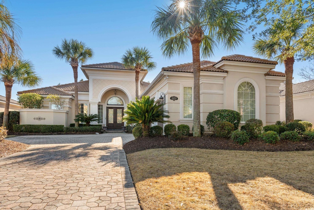 mediterranean / spanish-style home featuring a front yard and french doors