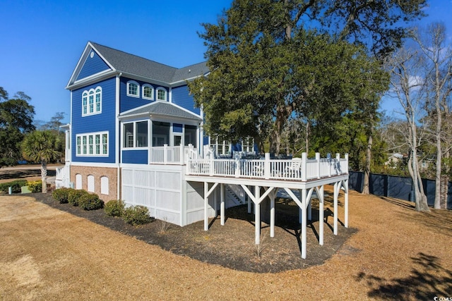 rear view of property with a wooden deck and a sunroom