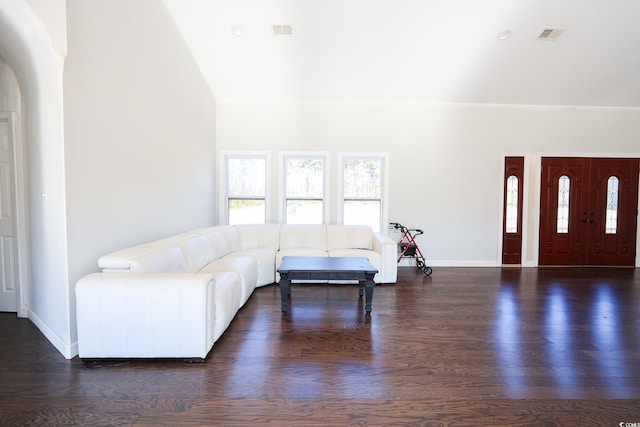 living area with wood finished floors, visible vents, and baseboards