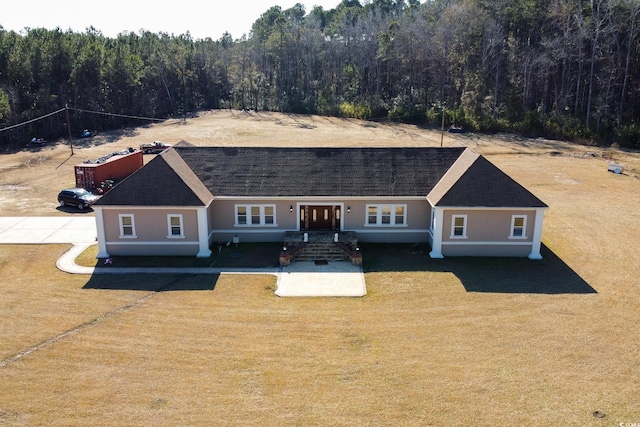 view of front facade with a view of trees and stucco siding