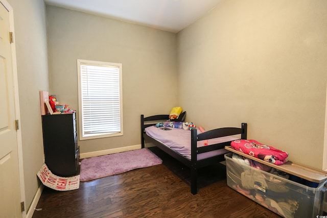 bedroom featuring baseboards and wood finished floors