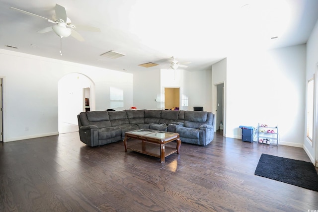 living area featuring arched walkways, visible vents, ceiling fan, and dark wood-style flooring