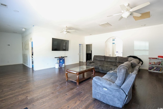 living room with visible vents, arched walkways, dark wood-type flooring, and ceiling fan