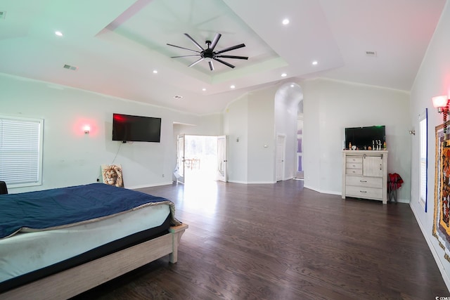 bedroom with a tray ceiling, recessed lighting, wood finished floors, and baseboards