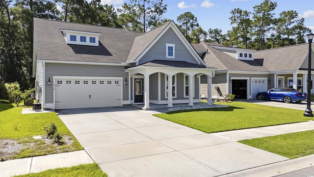 view of front of property with a garage, a front lawn, and a porch