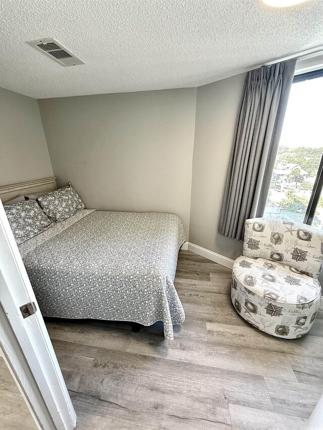 bedroom featuring a textured ceiling and wood-type flooring