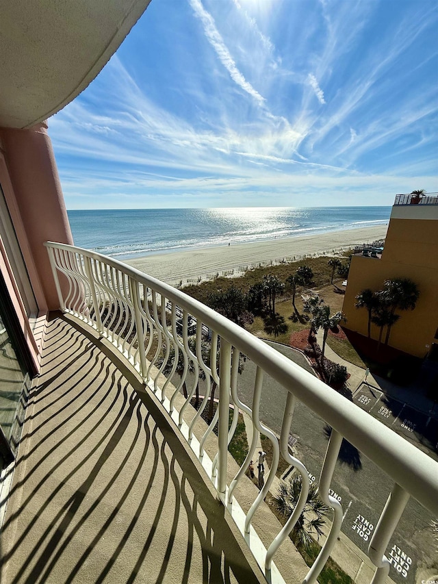 balcony with a water view and a view of the beach