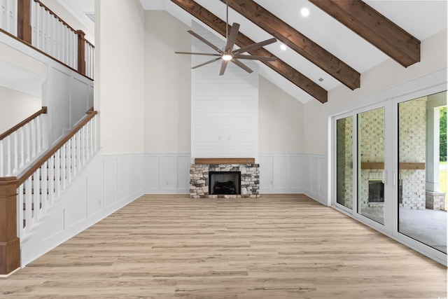7053 Byrnes Ln, Myrtle Beach, SC 29588 - unfurnished living room featuring beamed ceiling, a stone fireplace, ceiling fan, and wood finished floors