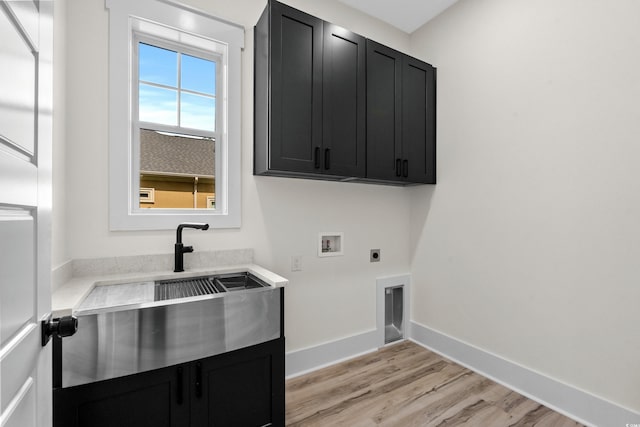 7053 Byrnes Ln, Myrtle Beach, SC 29588 - laundry room with hookup for an electric dryer, a sink, hookup for a washing machine, light wood-type flooring, and cabinet space