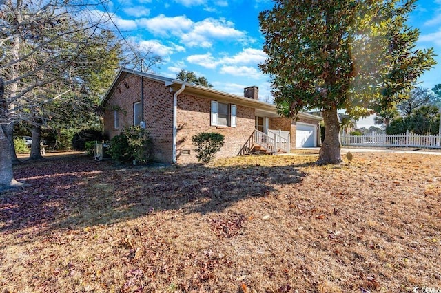 1020 Thomas Ave, North Myrtle Beach, SC 29582 - view of front of property featuring brick siding, fence, a chimney, and an attached garage