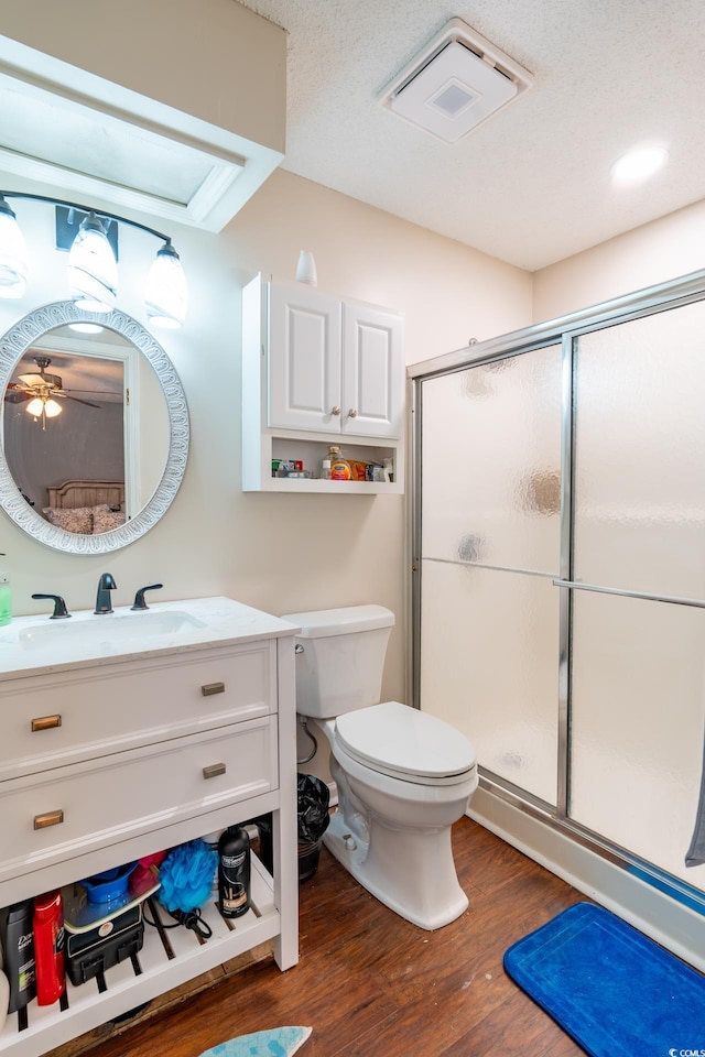 bathroom with vanity, hardwood / wood-style flooring, toilet, and walk in shower