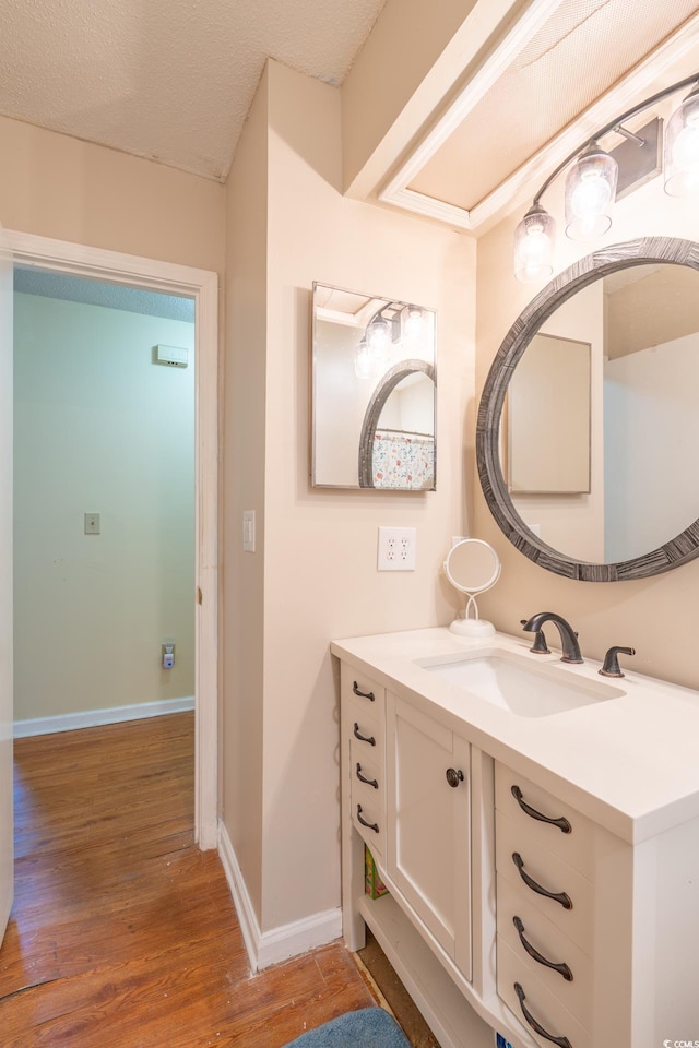 bathroom featuring vanity, hardwood / wood-style flooring, and a textured ceiling