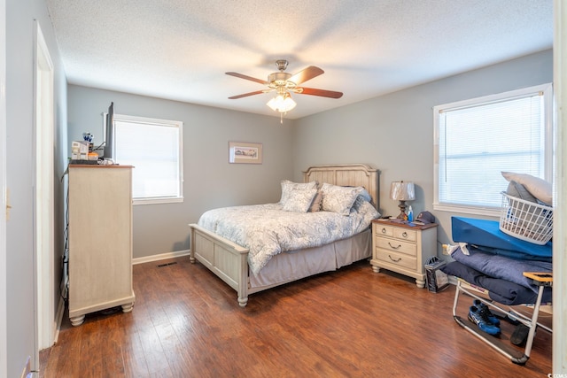 bedroom featuring a textured ceiling, dark hardwood / wood-style floors, and ceiling fan