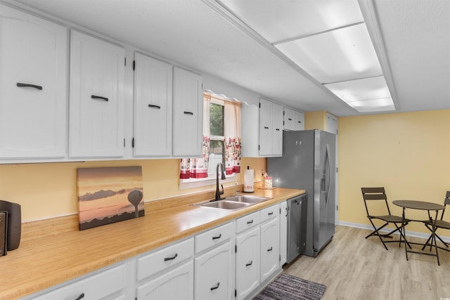 1020 Thomas Ave, North Myrtle Beach, SC 29582 - kitchen with a sink, appliances with stainless steel finishes, white cabinets, light wood finished floors, and light countertops