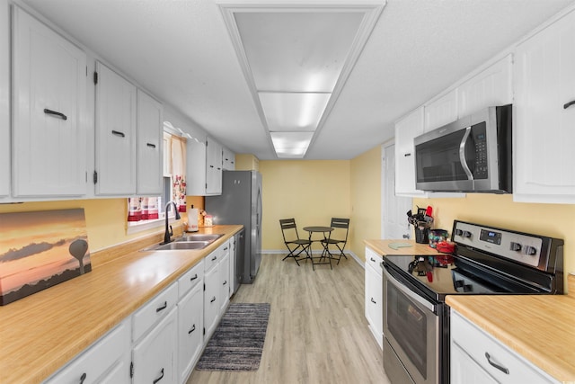 1020 Thomas Ave, North Myrtle Beach, SC 29582 - kitchen with stainless steel dishwasher, a sink, white cabinets, a ceiling fan, and light wood-type flooring