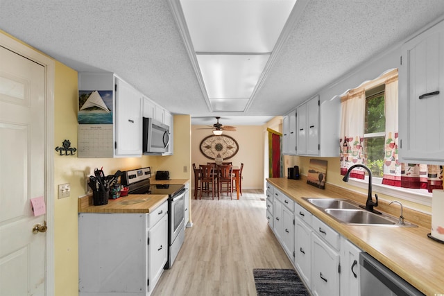 1020 Thomas Ave, North Myrtle Beach, SC 29582 - kitchen featuring stainless steel appliances, a sink, a ceiling fan, white cabinets, and light wood-style floors