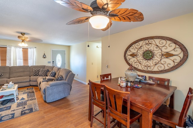 dining space with wood-type flooring and ceiling fan