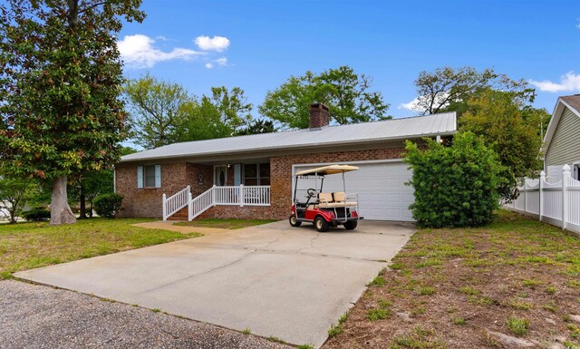 1020 Thomas Ave, North Myrtle Beach, SC 29582 - single story home with a garage, driveway, brick siding, a chimney, and metal roof