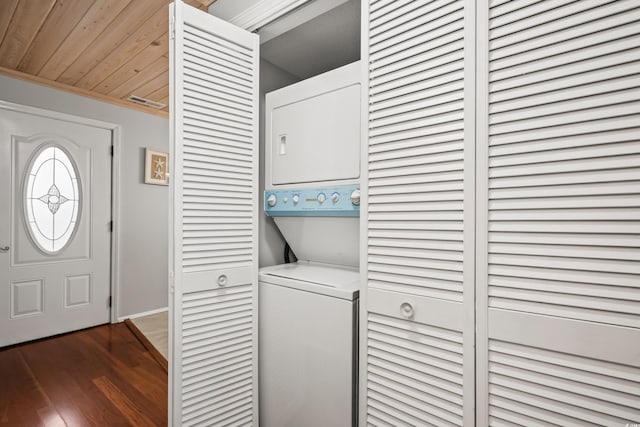 clothes washing area with stacked washer / dryer, wooden ceiling, dark wood-type flooring, and crown molding