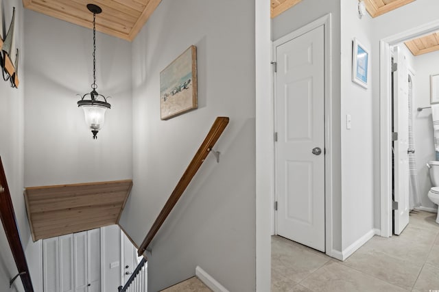 staircase featuring wood ceiling and tile patterned floors