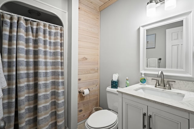 bathroom featuring toilet, wooden walls, curtained shower, and vanity