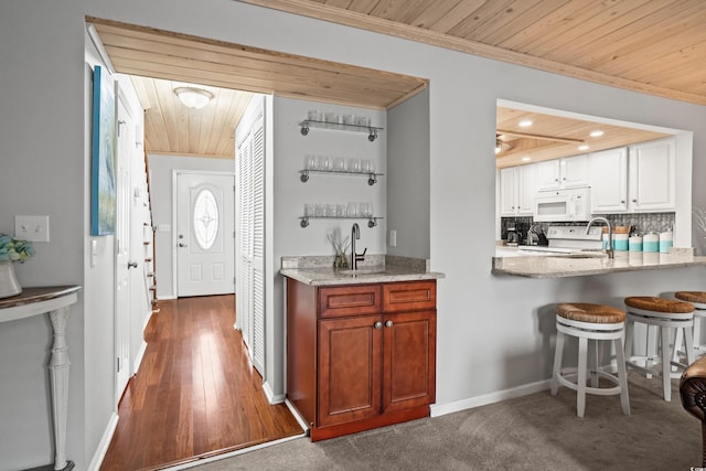 kitchen featuring crown molding, wood ceiling, stove, white cabinets, and backsplash