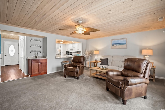 carpeted living room featuring crown molding, wooden ceiling, bar area, and ceiling fan