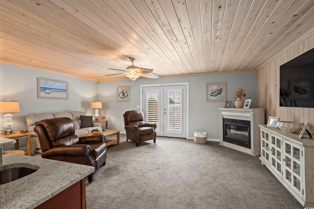 living room with french doors, crown molding, wood ceiling, and carpet flooring