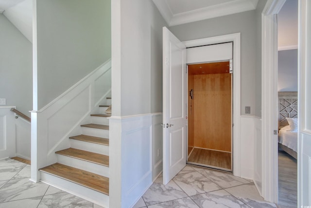 stairs with marble finish floor, a decorative wall, wainscoting, and crown molding