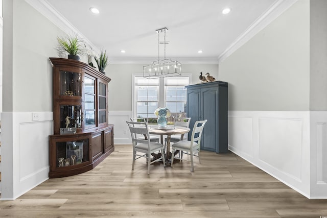 dining room featuring crown molding, a chandelier, and light wood-type flooring