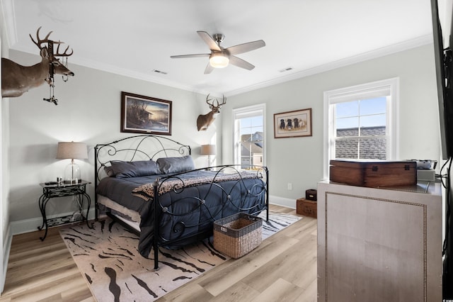 bedroom featuring crown molding, light hardwood / wood-style floors, and ceiling fan