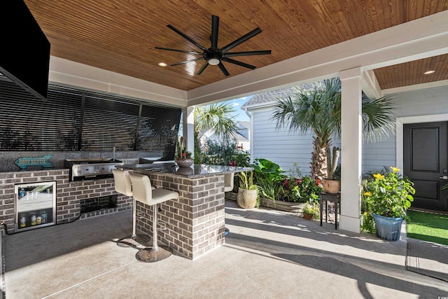 view of patio with a grill, ceiling fan, and a bar