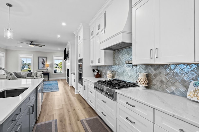 kitchen featuring white cabinetry, appliances with stainless steel finishes, sink, and pendant lighting