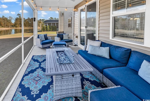 sunroom / solarium featuring a water view and track lighting