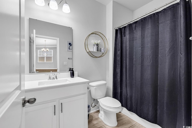 bathroom with vanity, toilet, and an inviting chandelier