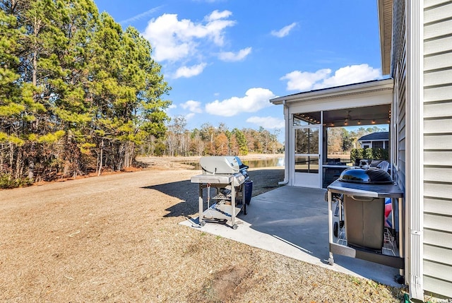 view of patio with area for grilling and a sunroom