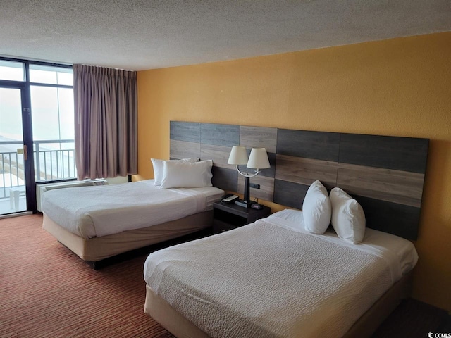 carpeted bedroom featuring access to outside and a textured ceiling