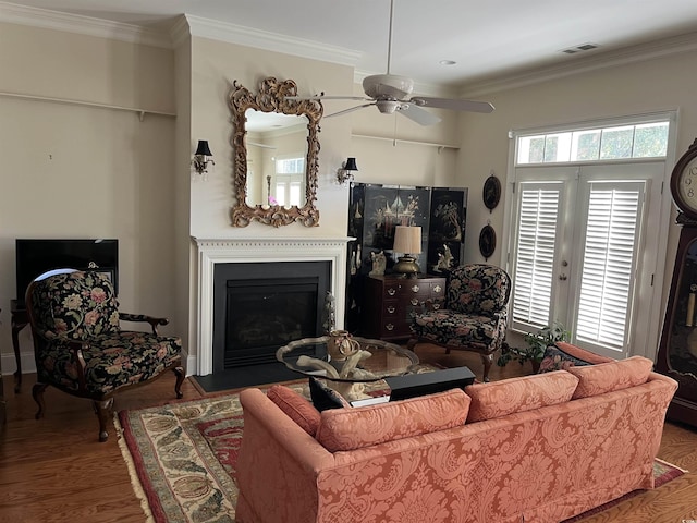 living room featuring crown molding, ceiling fan, and hardwood / wood-style flooring