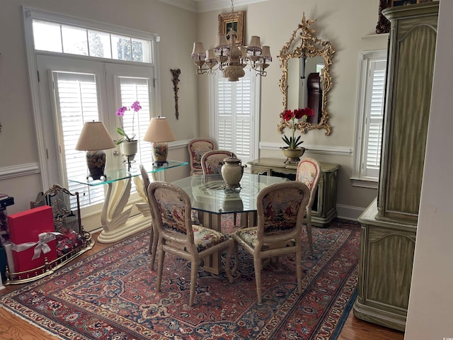 dining space featuring a wealth of natural light, ornamental molding, a chandelier, and wood-type flooring