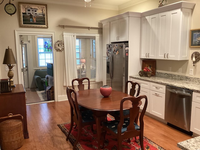 kitchen with white cabinetry, light stone countertops, light hardwood / wood-style flooring, and stainless steel appliances