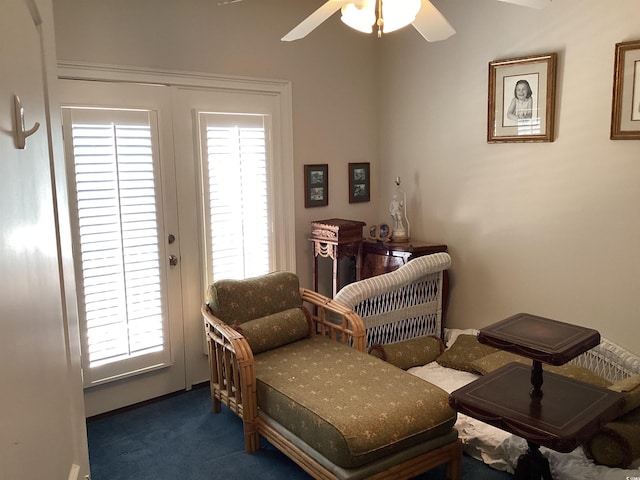 sitting room featuring dark colored carpet and ceiling fan