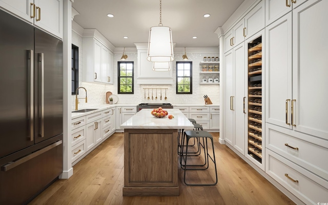 kitchen featuring white cabinetry, built in fridge, and a sink