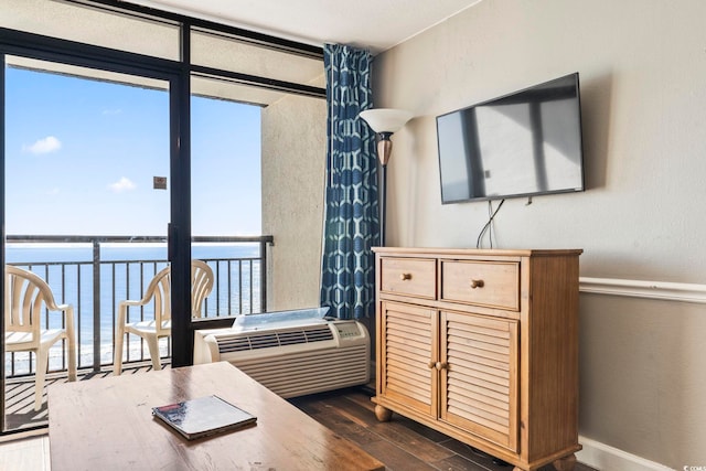 interior space with floor to ceiling windows, dark hardwood / wood-style floors, and a water view