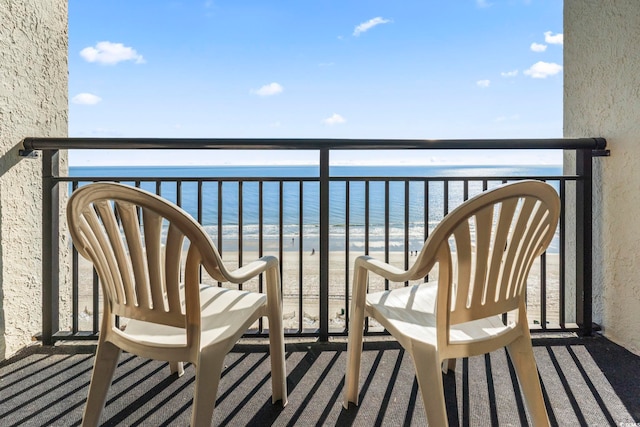 balcony featuring a beach view and a water view