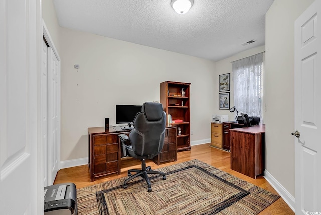 office area featuring a textured ceiling and light wood-type flooring