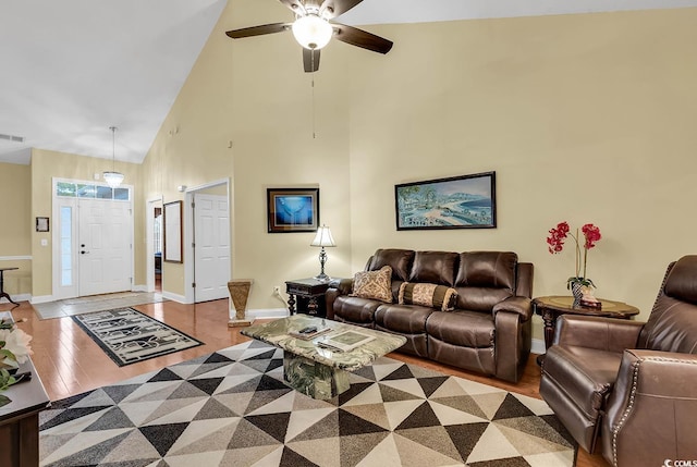 living room featuring ceiling fan, light wood-type flooring, and high vaulted ceiling