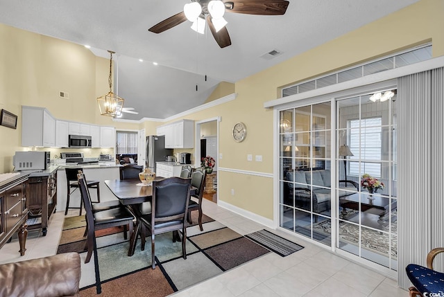 tiled dining area featuring lofted ceiling and ceiling fan with notable chandelier