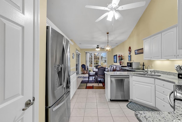 kitchen featuring light tile patterned flooring, sink, white cabinetry, appliances with stainless steel finishes, and kitchen peninsula